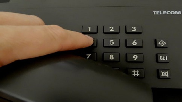 une main qui compose un numéro sur un interphone-plateforme téléphonique médicale-Serenity