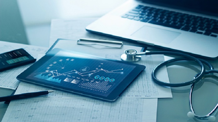 une tablette, des fiches patients, un stéthoscope, et un ordinateur portable sur une table-secrétariat médical externalisé-serenity 