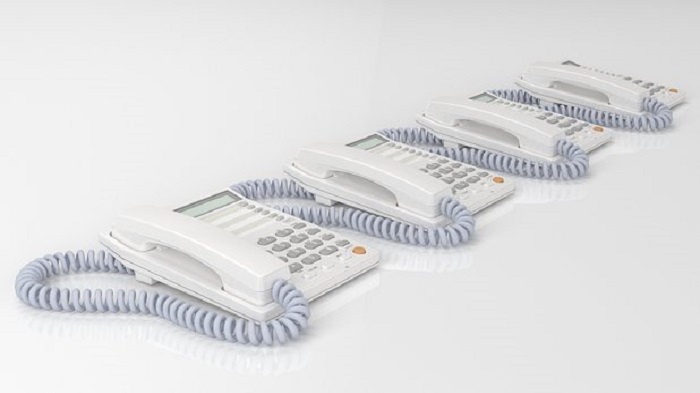 Trois téléphones fixes qui s'alignent sur une table blanche - accueil téléphonique - Serenity 