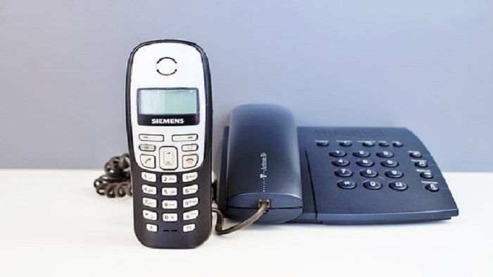 un téléphone portable et un téléphone fixe sur une table - centre d'appel - Serenity 