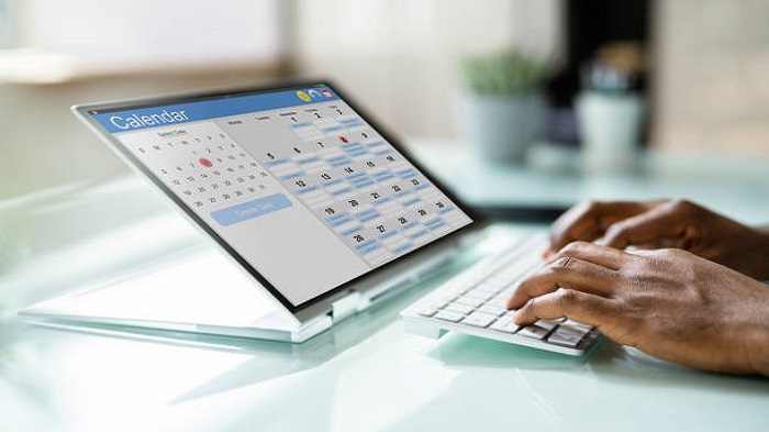 une main sur un clavier et une tablette affichant un agenda électronique -gestion des agendas des médecins-Serenity