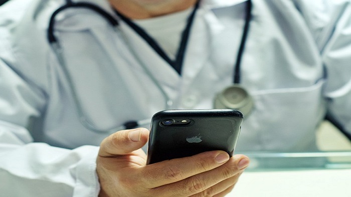 un docteur tenant un téléphone dans la main - permanence téléphonique médicale - Serenity