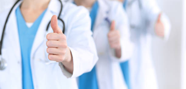 Groupe de médecins montrant le signe OK avec le pouce en l'air en gros plan - entreprise de télésecrétariat - Serenity