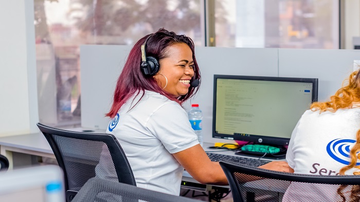 une télésecrétaire souriante sur son plateau de travail - standardiste téléphonique médical - Serenity