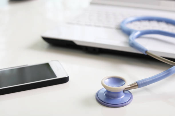 un stéthoscope, un téléphone et un laptop sur une table - externaliser le secrétariat téléphonique médical - Serenity