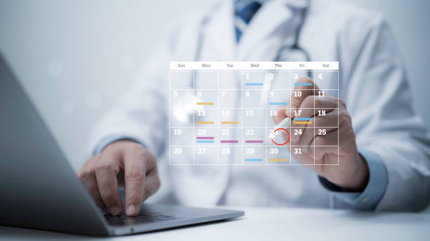 Le travailleur médical avec le calendrier numérique virtuel sur l'ordinateur portable pour planifier un rendez-vous - gestion des agendas médicaux - Serenity