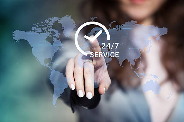 Une femme d'affaires appuie sur le bouton d'assistance 24h/24 et 7j/7 sur une carte du monde - permanence téléphonique à distance - Serenity