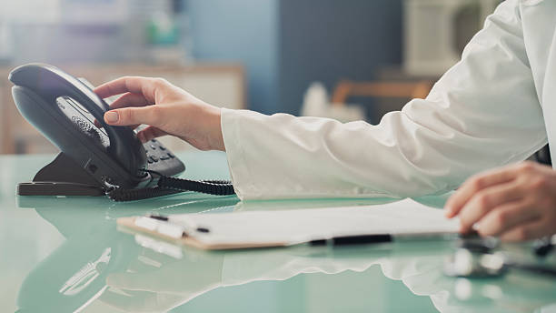 Médecin répondant au téléphone au bureau d'accueil médical - télésecrétariat médecin général - Serenity